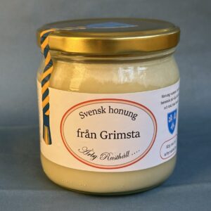 Glasburk med ljus honung. Texten "från Grimsta" står med stora bokstäver i en röd oval.